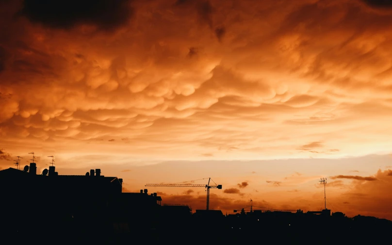 this is the sun setting over a city with clouds