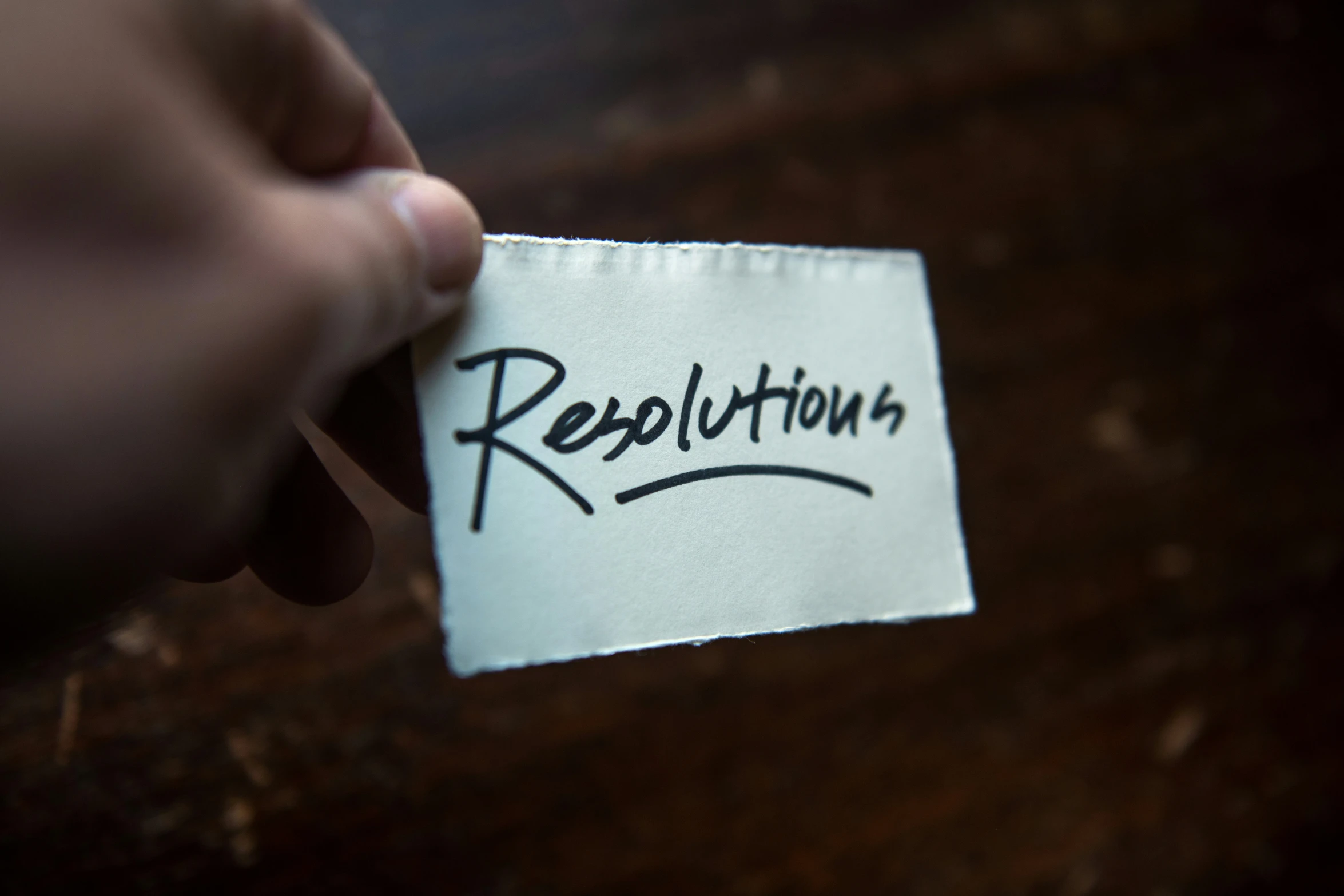 a person holding a piece of paper with the word resolution drawn on it