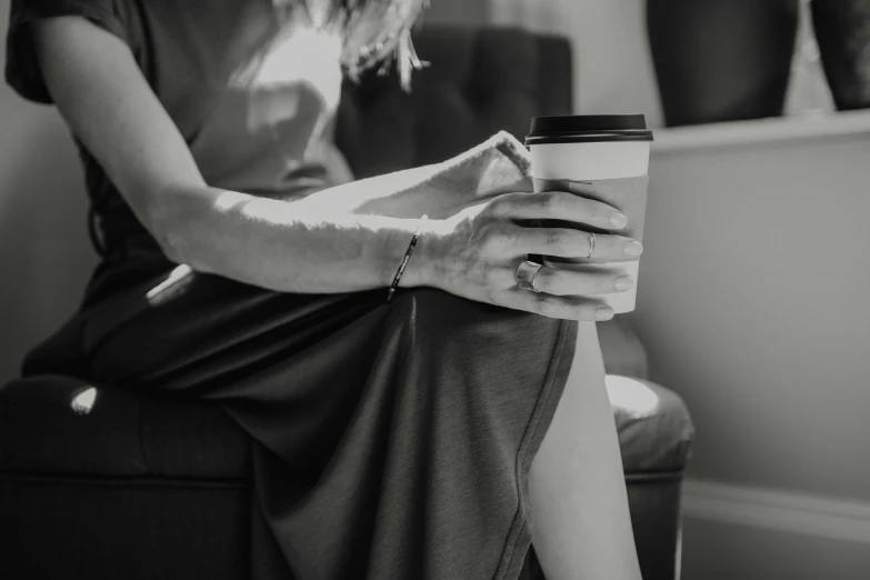 a person sitting and holding a coffee cup