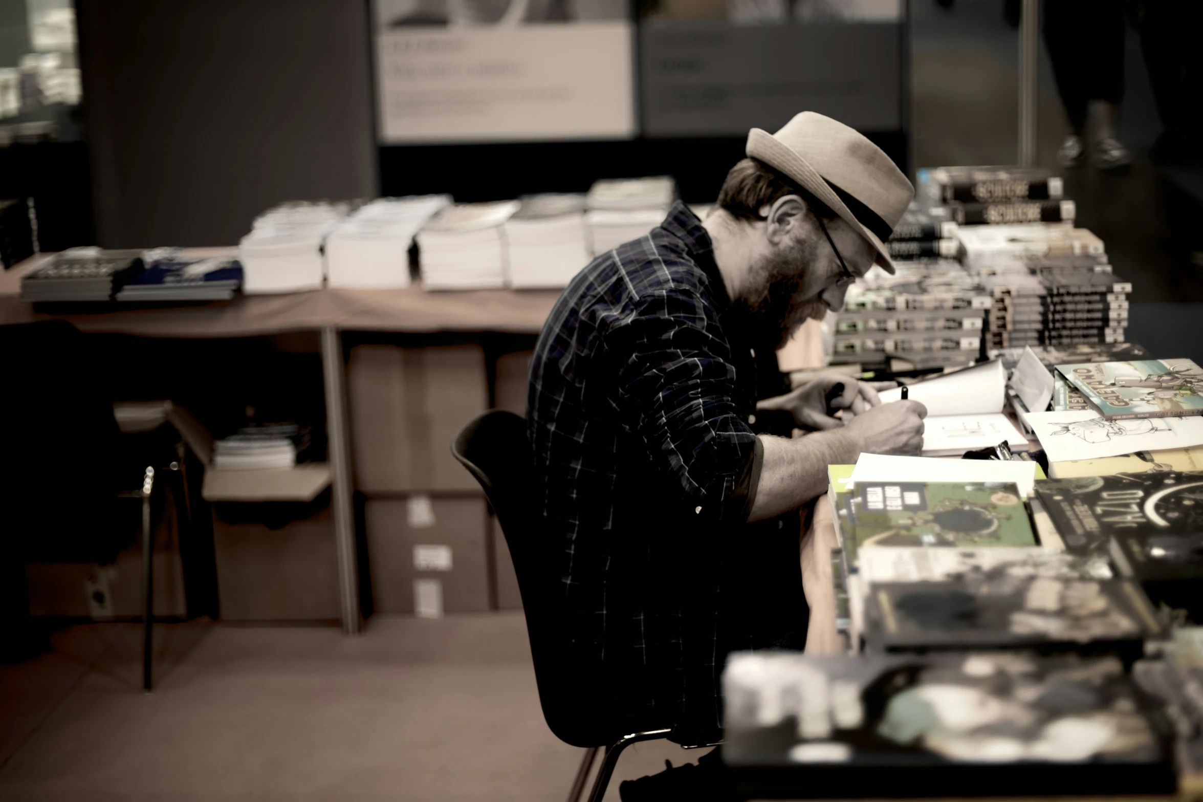 a man is sitting at a desk using a cell phone