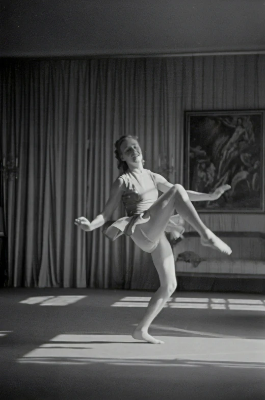 a woman in a dance pose, with her legs bent forward