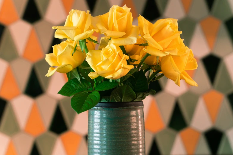 a vase filled with yellow flowers against a wall