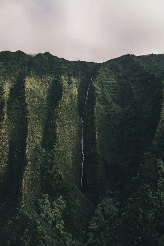 a very high side mountain with a long waterfall