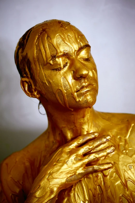 a gold statue holding onto someones chest