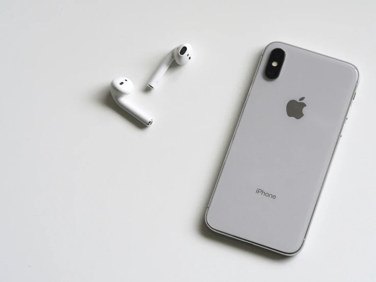 a phone and ear phones laid out on a white surface