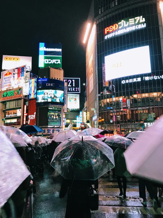 people walking in the rain holding umbrellas outside a cityscape