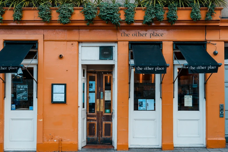 two large doors in front of an orange building