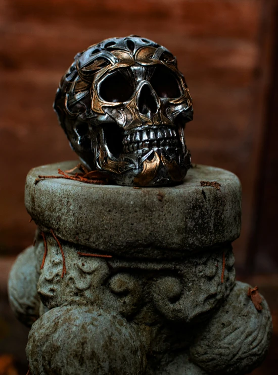 a skull sitting on top of a stone statue