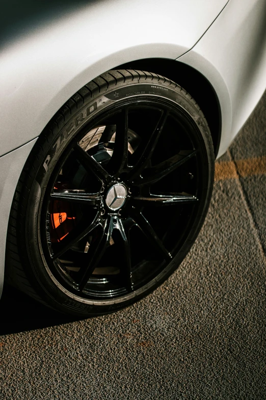 the rim of a silver sports car on the ground