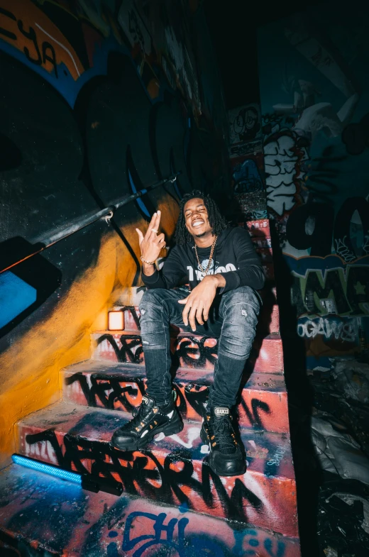 a man sitting on stairs wearing black boots