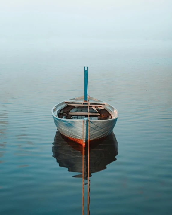 a boat floating on water next to a rope