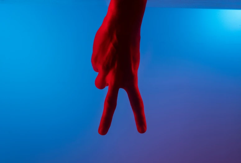 a red glove hanging on a blue wall