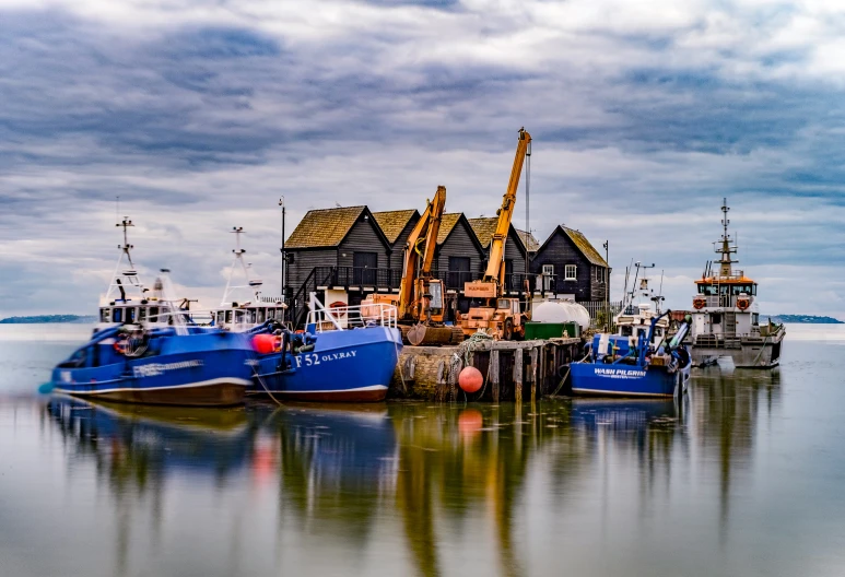 a blue boat next to several houses sitting on top of the water