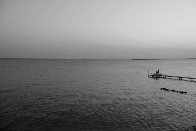 a black and white po of a pier at sea