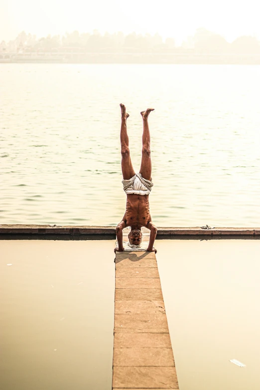 a person on a skate board leaning forward over the water