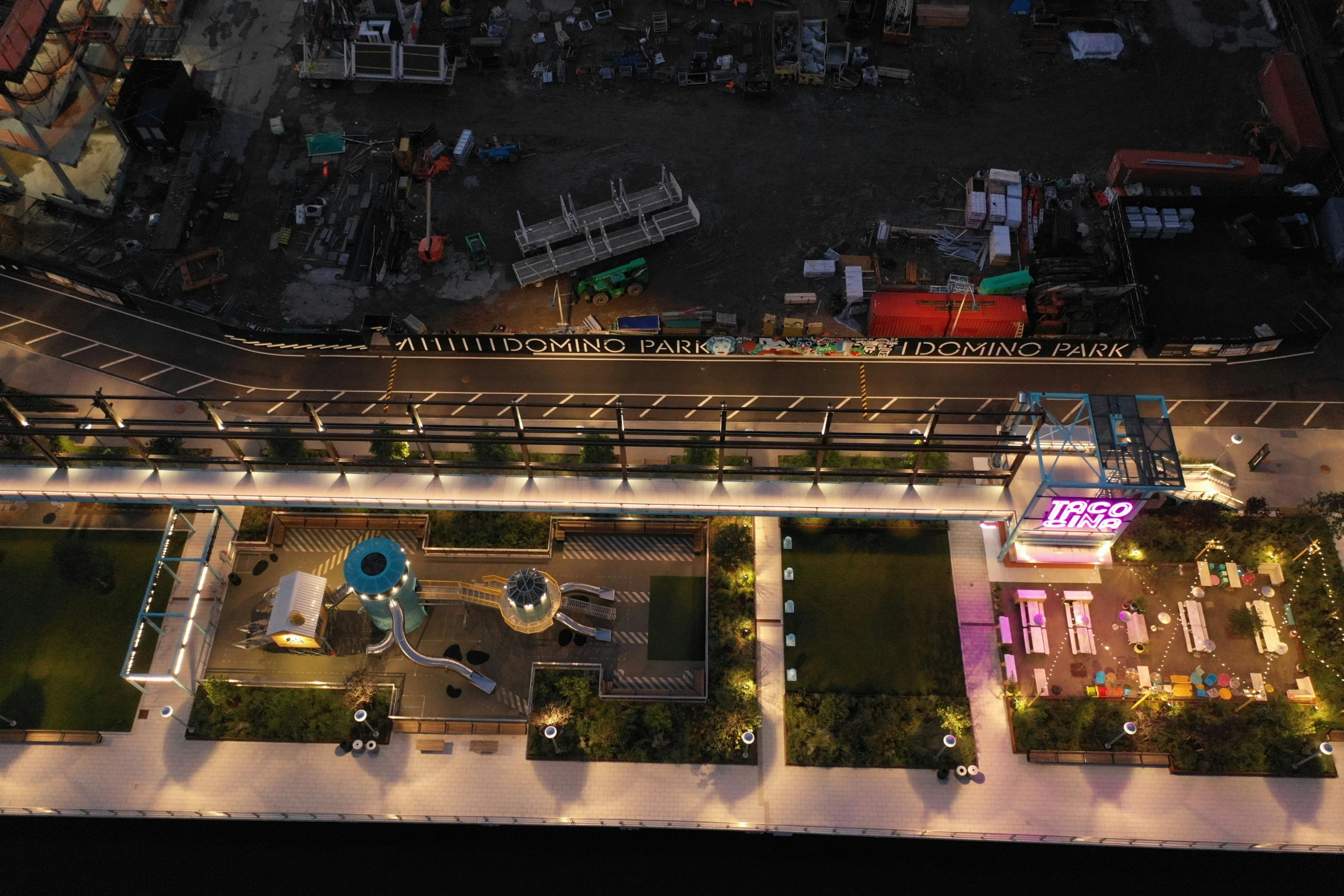 a night view shows the parking lot, a shopping center and a building