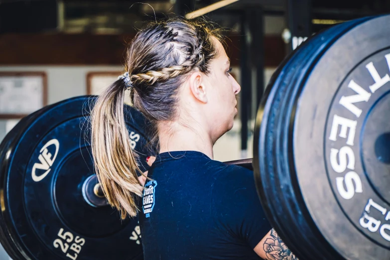 a woman lifting a heavy disk in the gym