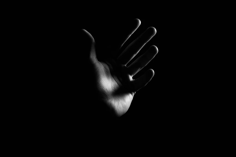 a hand extended up in the dark with it's fingers out