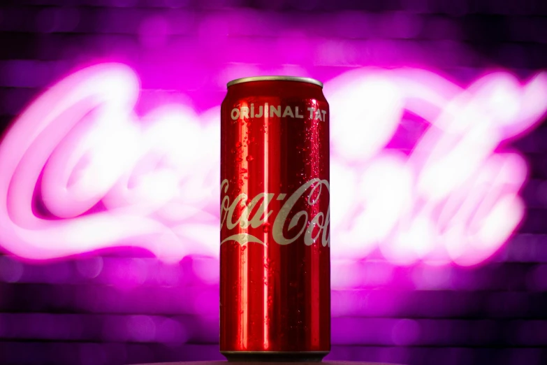 a bright red can of coca - cola sitting on a table