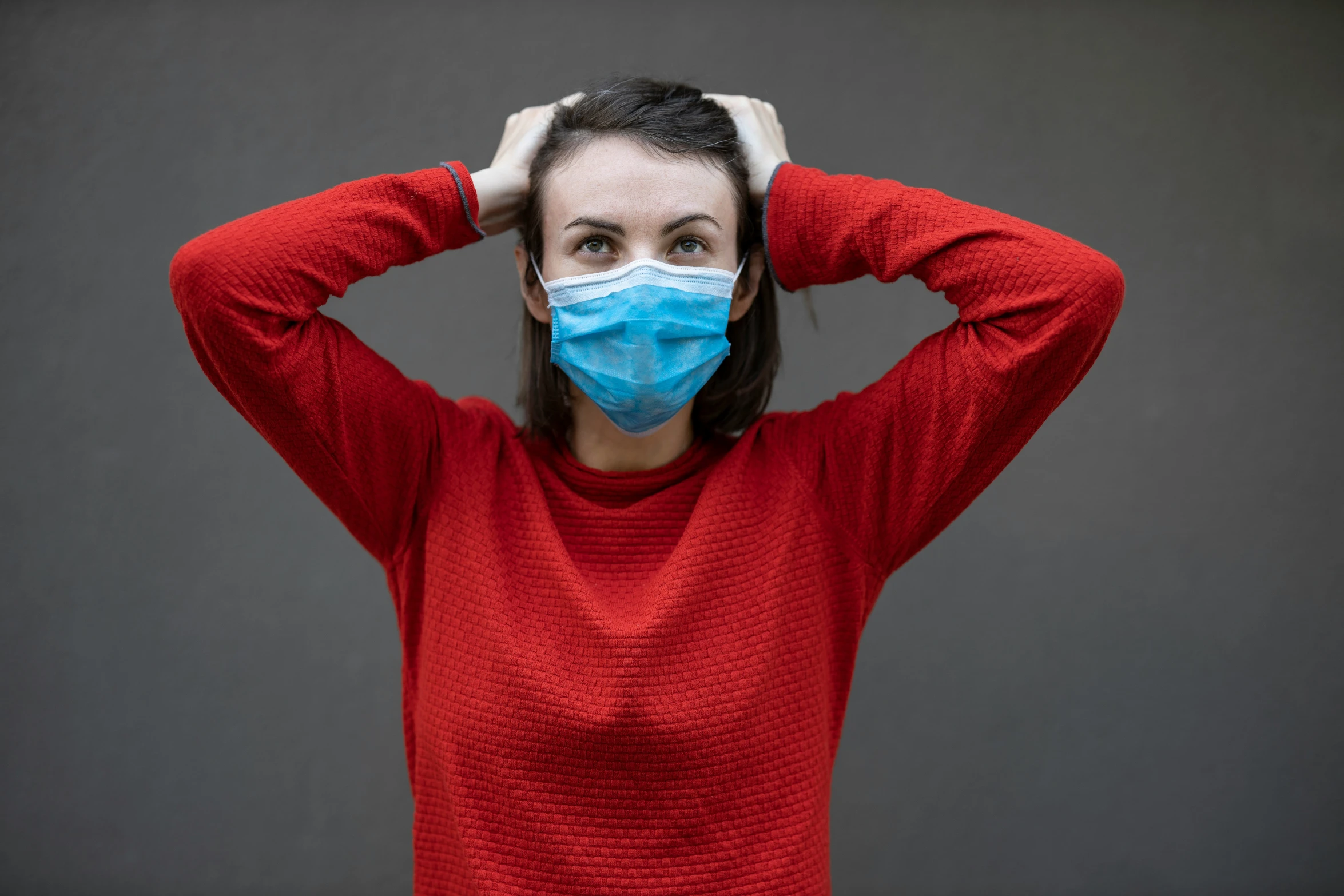 a girl wearing a blue mask and holding her head