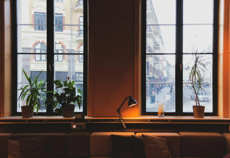 a living room with large windows, plants and candles on the table