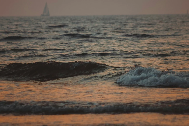 a sailboat in the distance behind some dark water