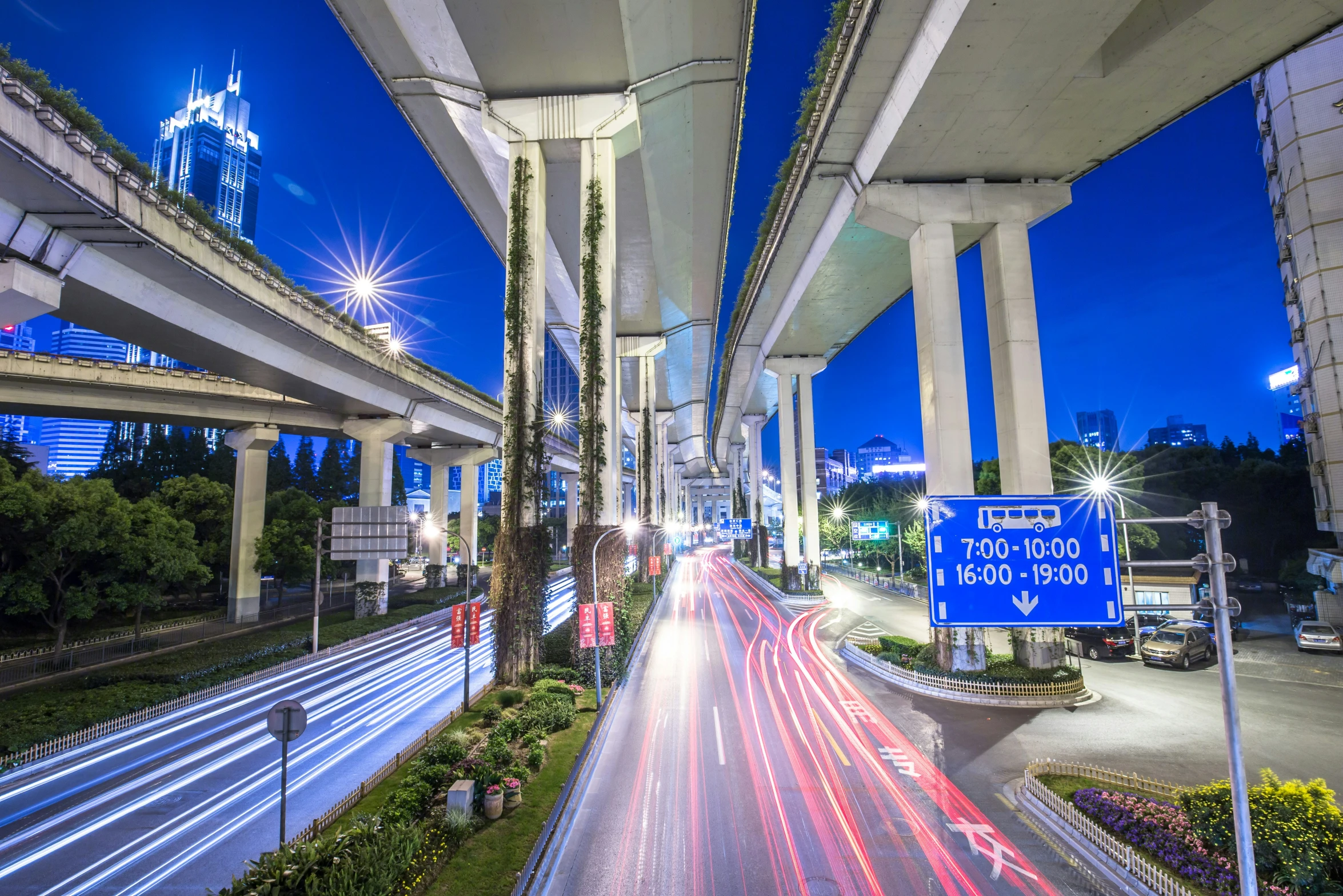 a street scene with lights and cars driving under a bridge