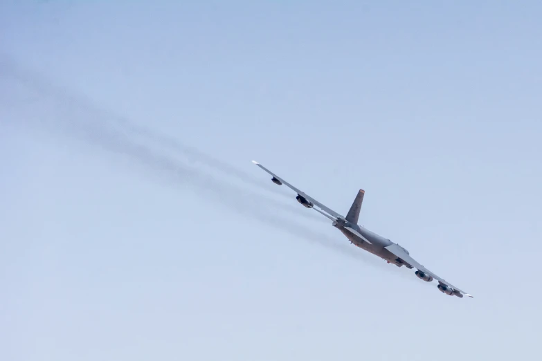 a fighter jet flying through the air with two vapor trails