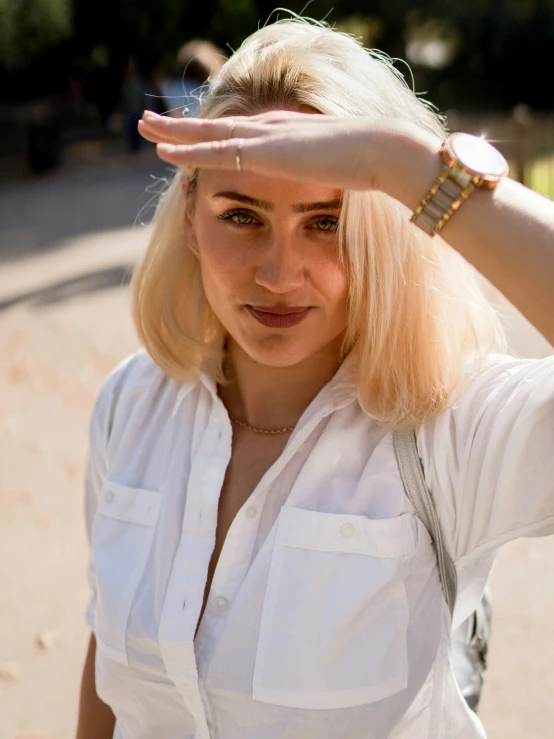 a woman in a white shirt holds her hand up