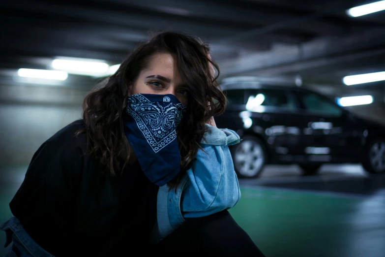 there is a woman that is holding up a bandana in a car park