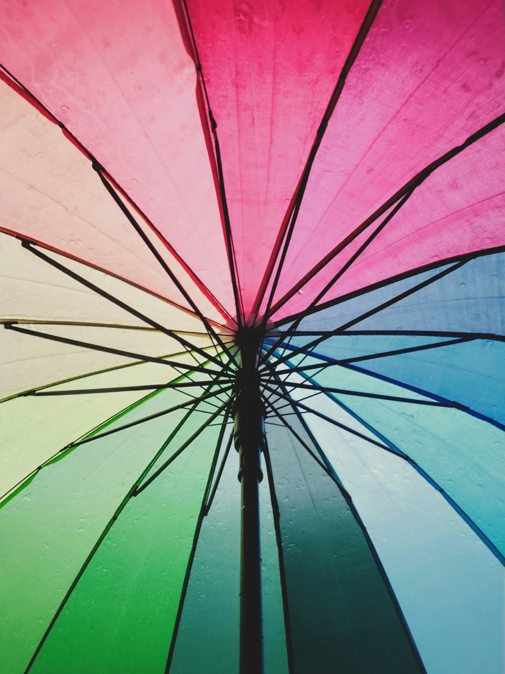the rainbow umbrella is partially open and ready for you to use