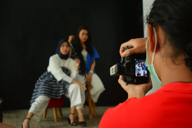 a woman in red is taking a picture of herself with a camera