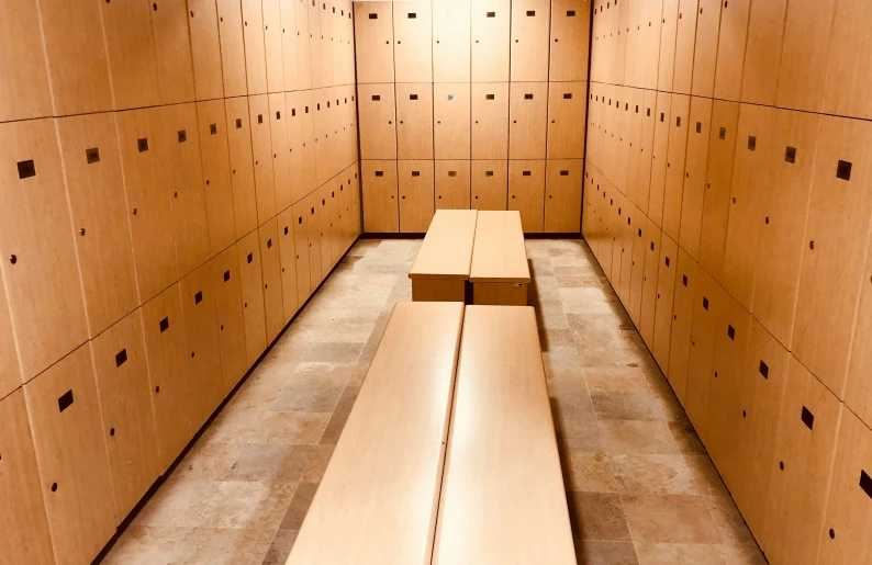 wooden benches lined up in the corner of an empty room