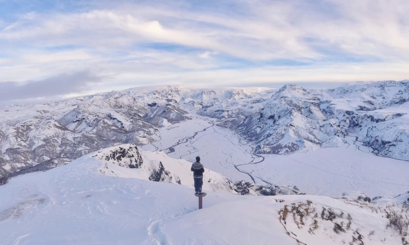 a person on skis on a mountain with mountains in the background