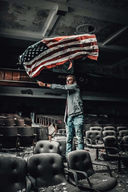 a man in the midst of a demolished auditorium with an american flag