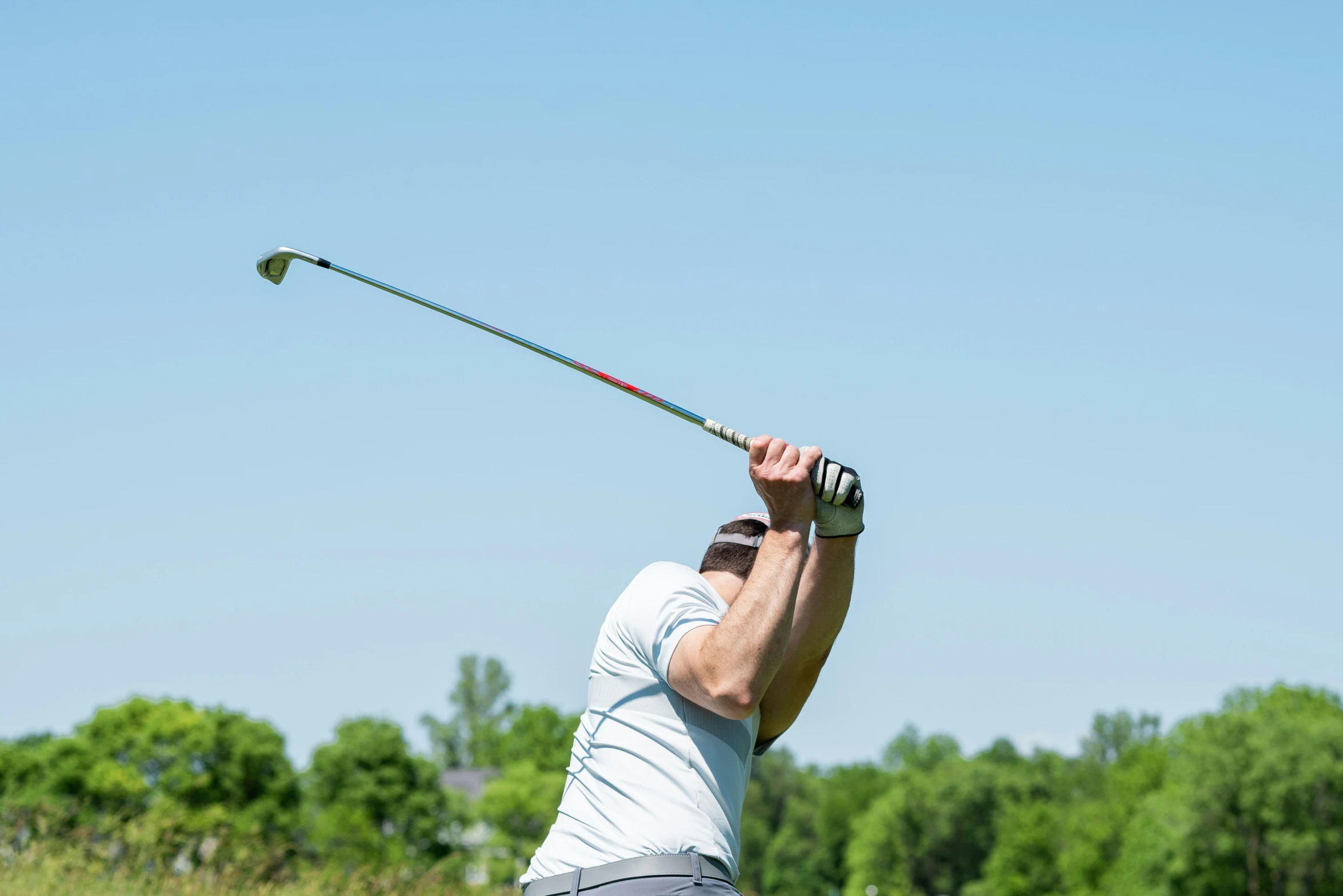 a person in shorts swings a golf club with their fingers