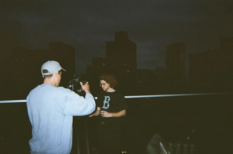 a man standing next to a woman and holding a camera