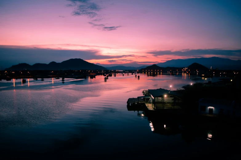 the setting sun shines on some boats anchored in a harbor