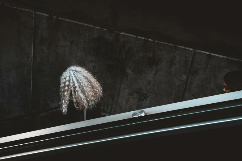 two people are on a window sill staring out a city