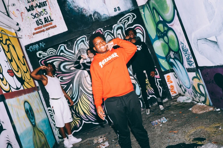 the people stand around in an alley covered with graffiti