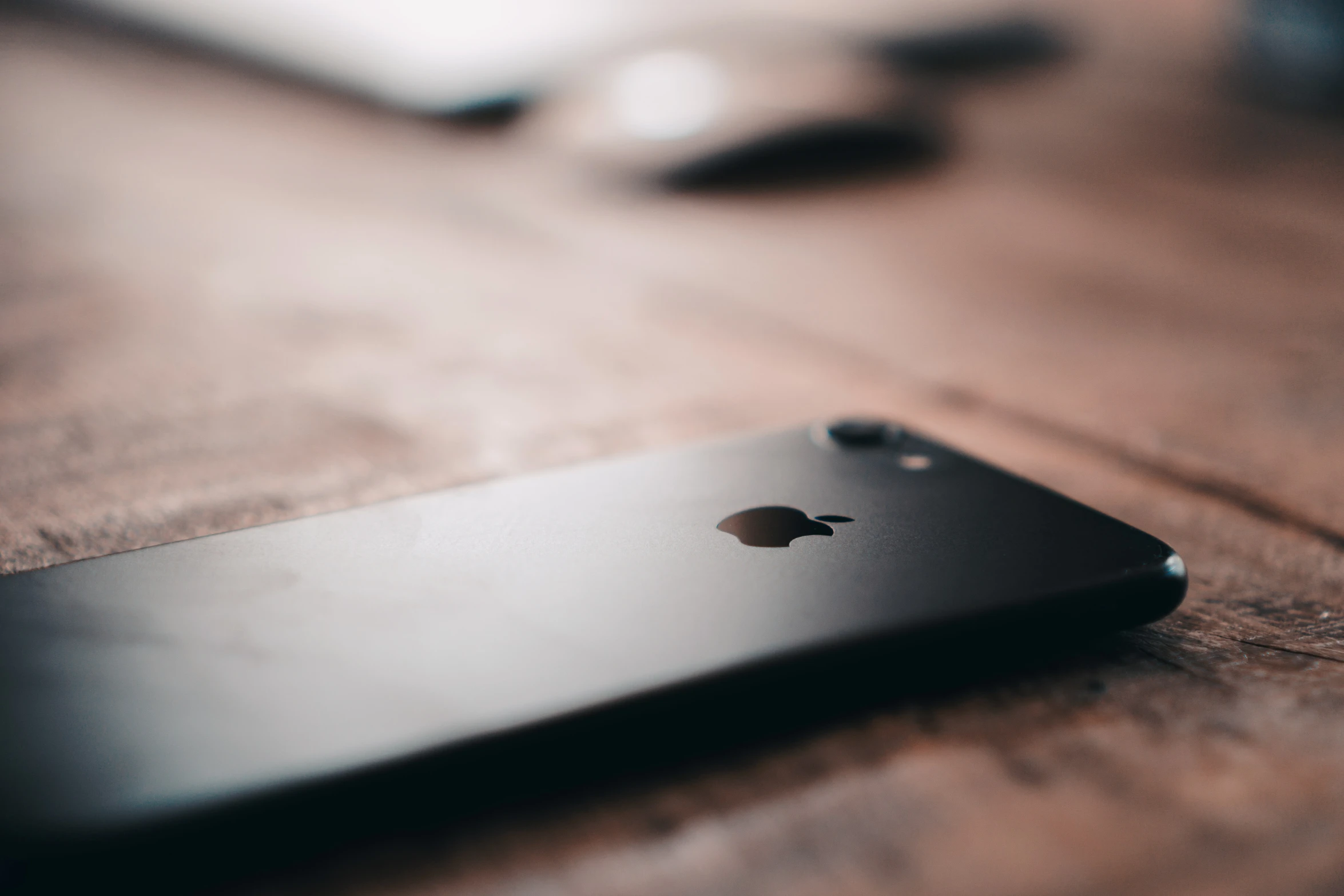 an iphone sitting on top of a wooden table