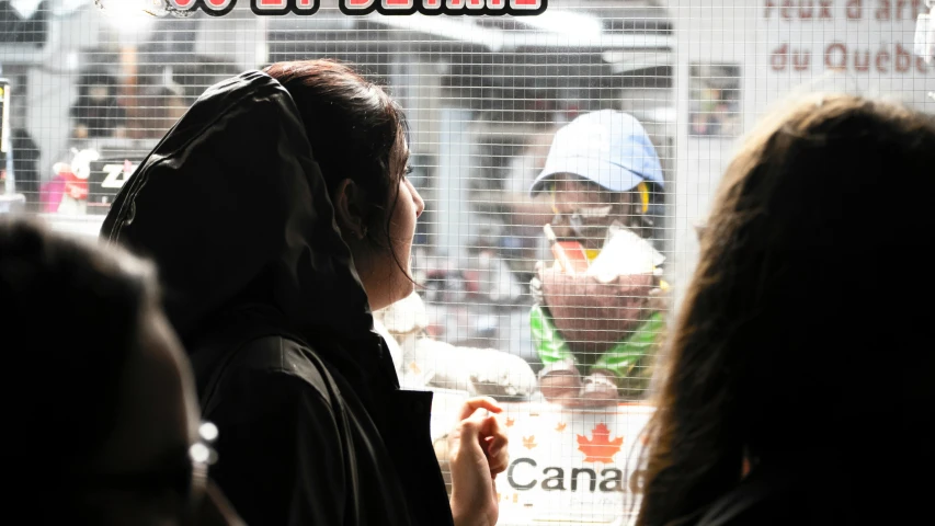 a man with a bandana standing in front of a store window