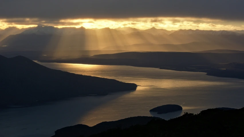 sun rays breaking through clouds over the ocean