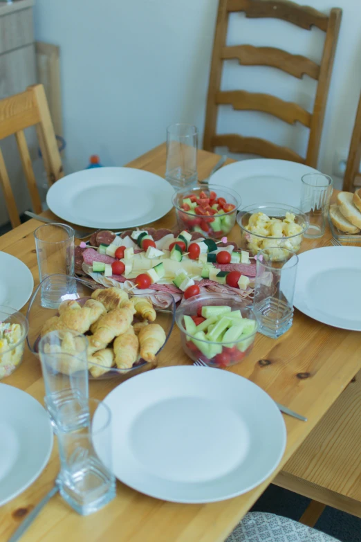 a dinner table is decorated with small appetizers and bread