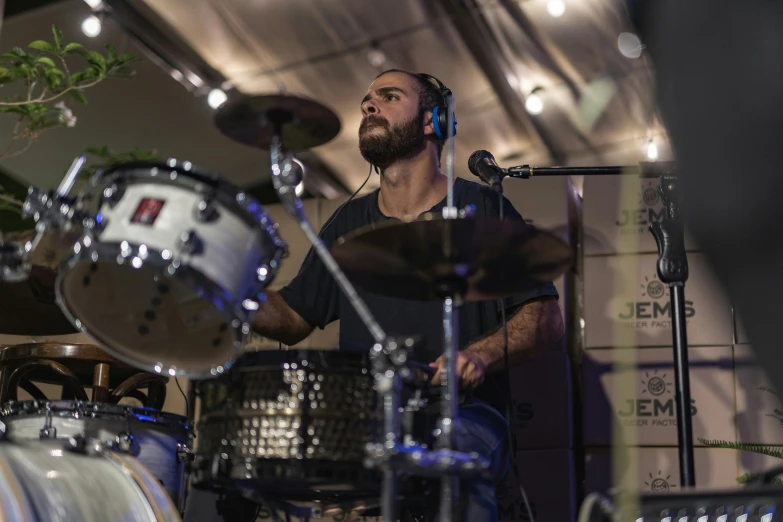 a man wearing headphones playing drums and recording