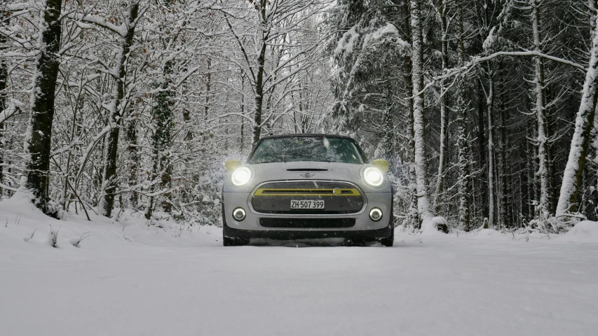 a car driving on a snowy road in a wooded area