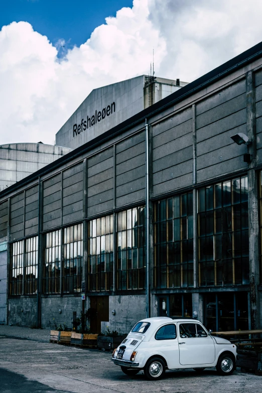 a white car is parked outside a large building