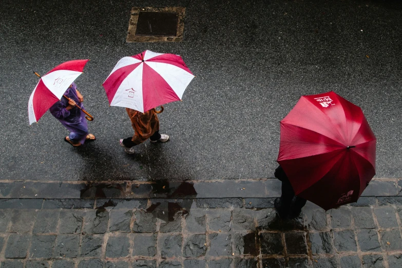 people with umbrellas walking on a street in the rain