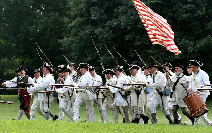 a group of men with uniforms holding onto different flags