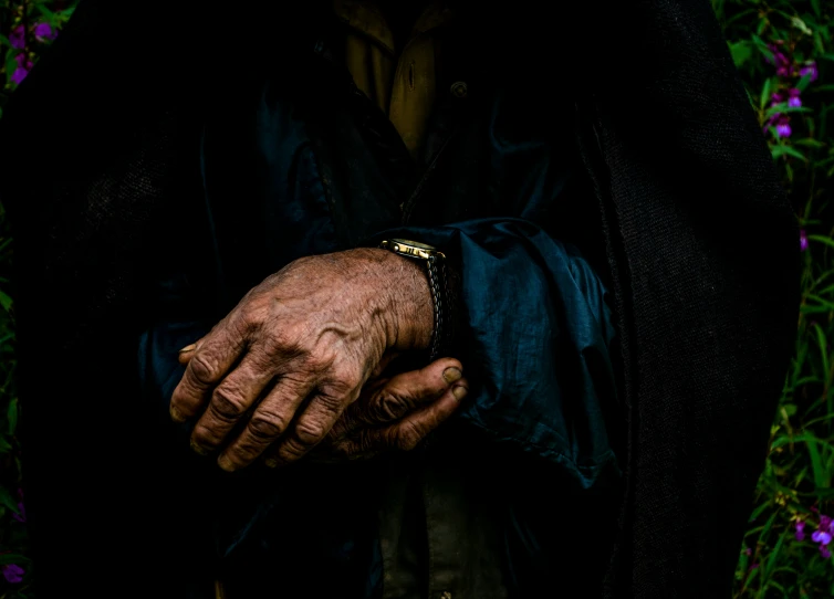 a person is standing in the flowers with their hands on the pocket of a jacket